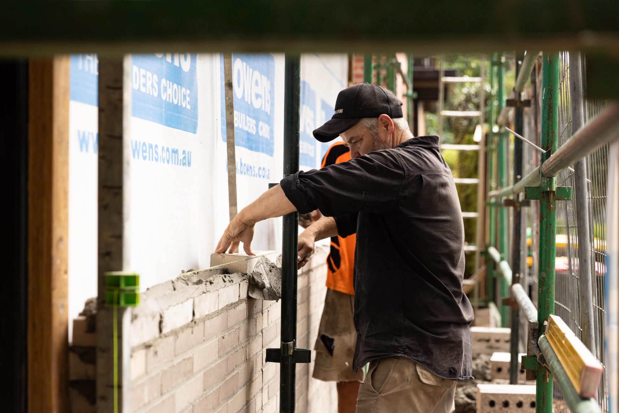 Bricklayer laying a new brick wall on an Elwood house site
