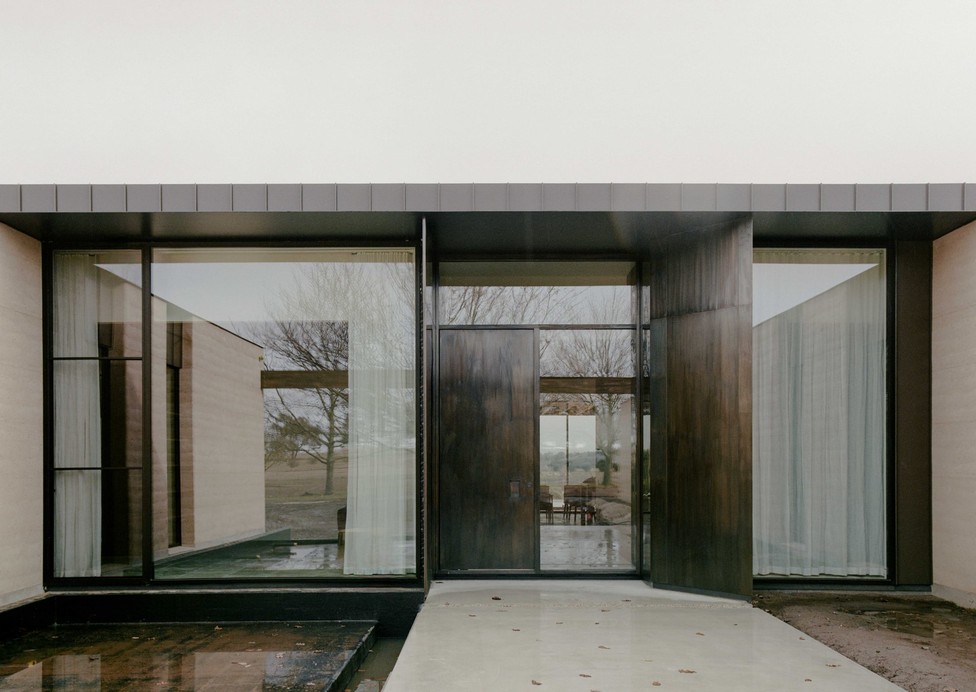 Glazed entry court of a rammed-earth house in the Macedon Ranges